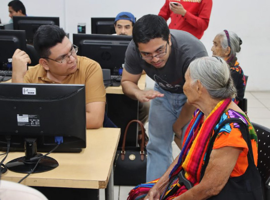 Two men speak to a woman at the El Salvador Chapter Náhuat Editathon