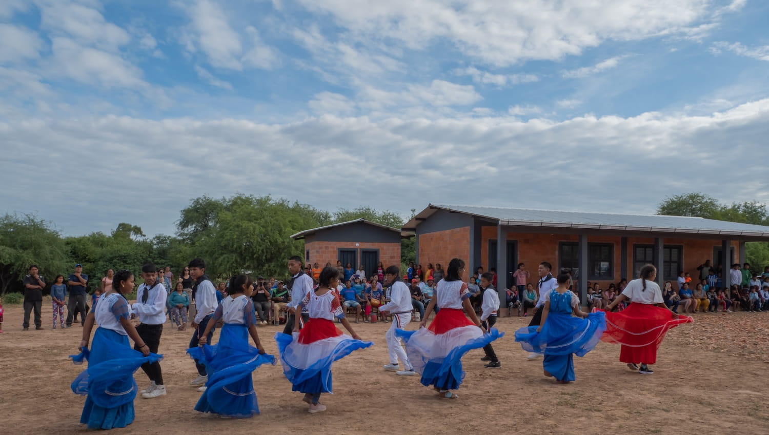 A lively gathering of individuals in colorful attire dancing together