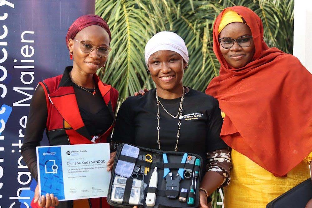 Three women smile and stand together at the Mali Chapter DDCN graduation